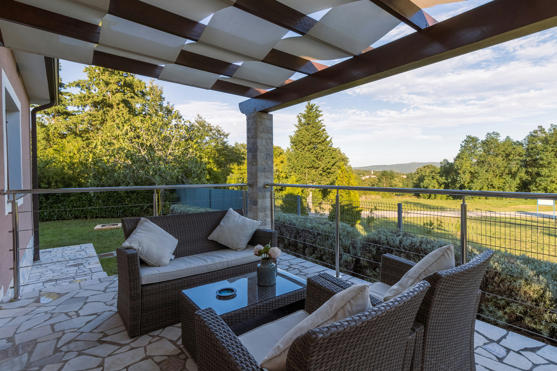 Natursteintetrasse im Garten mit Gartenmöbeln